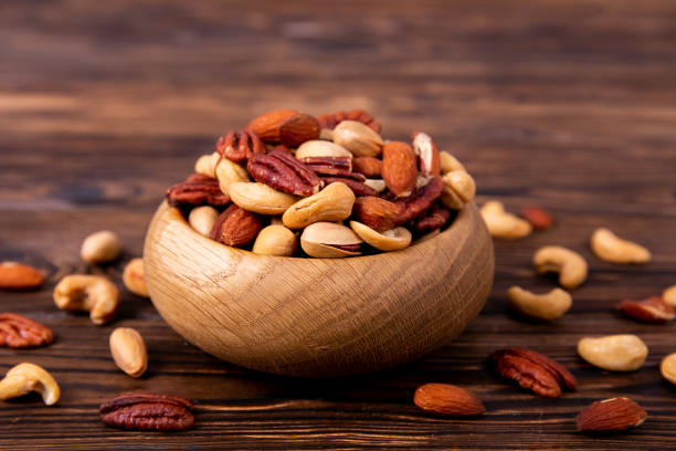 istock Different kinds of organic nuts in wooden bowl. 1089299036