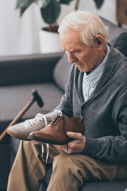 istock senior man choosing between classic and modern shoes 1089300400