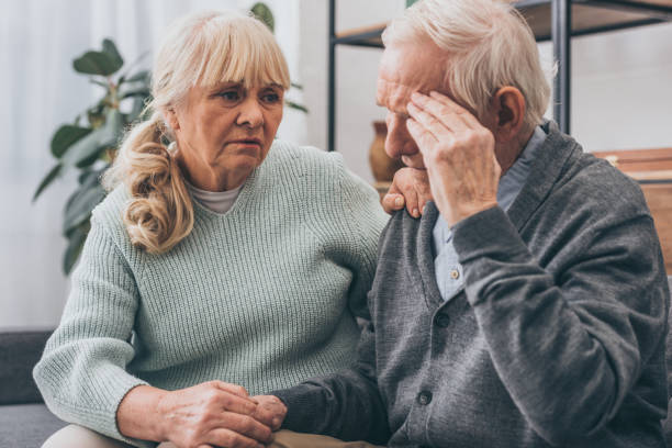 istock retired woman holding hands with senior husband having headache 1089300430