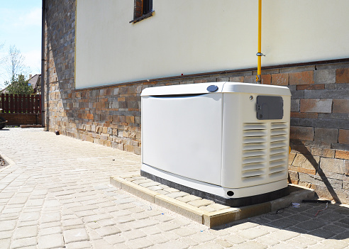 Generador de respaldo de gas natural de casa residencial. Elegir una ubicación para el generador de reserva de casa. photo