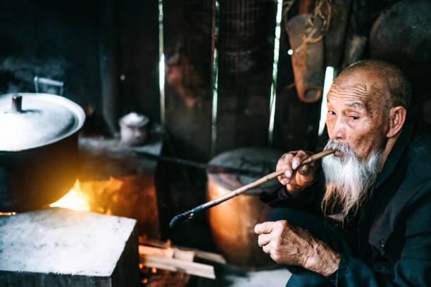 istock Old Senior Chinese man in kitchen smoking pipe 1089303370