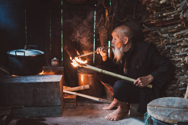istock Old Senior Chinese man in kitchen smoking pipe 1089303402