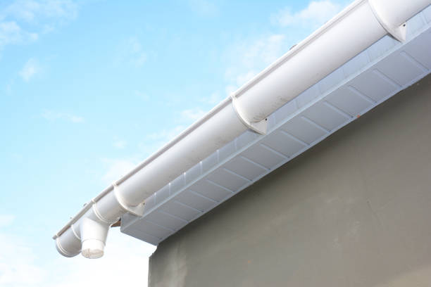 istock Roof gutter repair. Rain gutter installation with drain downspout pipe. Guttering with soffits and fascia board. 1089313384