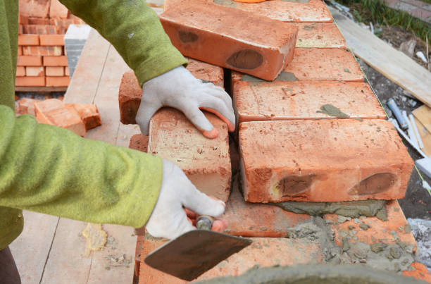 istock Bricklayers hands in masonry gloves bricklaying on House Construction Site. 1089313876