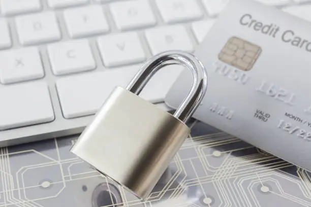 Photo of Padlock and credit card on keyboard and electronic circuits.