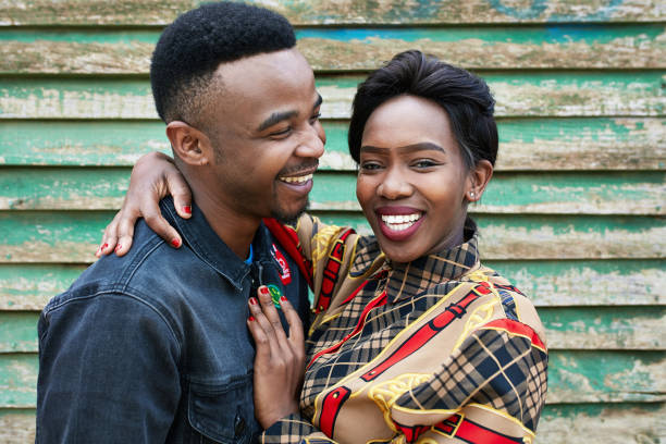 istock Smiling young woman embracing man against shack 1089321152