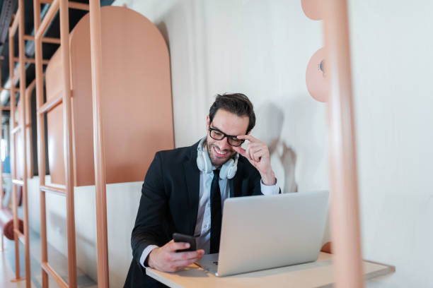 istock Successful young businessman sitting at the table and using smart phone. On table laptop. 1089321948
