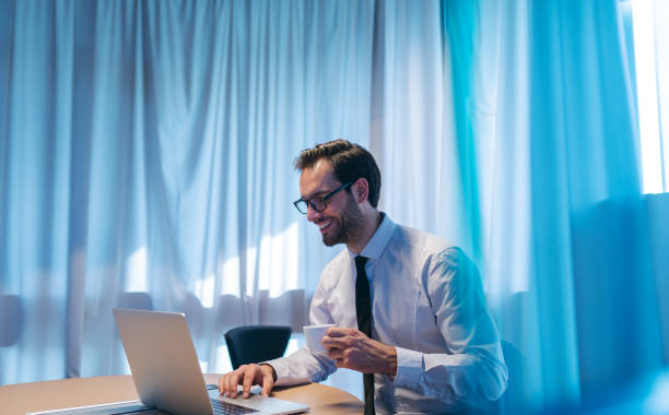 istock Portrait of successful smiling businessman using laptop and drinking espresso while sitting in his office. 1089322334