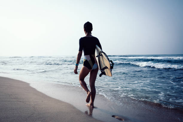 istock Surfer woman with surfboard walking on tropical beach 1089326826