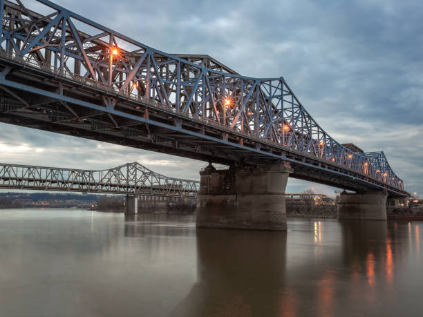 istock Two steel bridges crossing calm brown river 1089330006