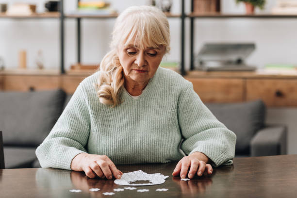 istock senior woman looking at puzzle pieces on table 1089332956