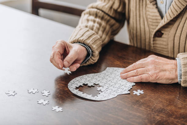 zugeschnittenen überblick senior woman spiel mit rätsel - alzheimer krankheit stock-fotos und bilder