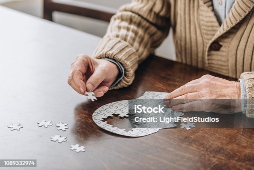 istock cropped view of senior man playing with puzzles 1089332974