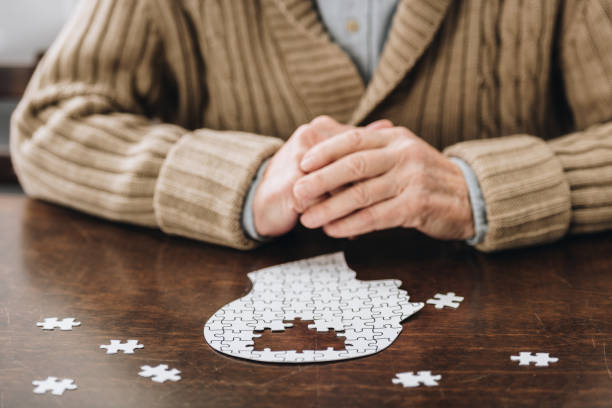 istock cropped view of senior man playing with puzzles on table 1089332986