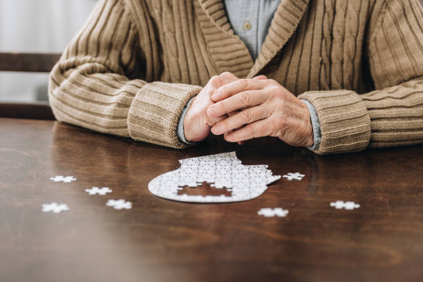 istock cropped view of retired man playing with puzzles on table 1089332988