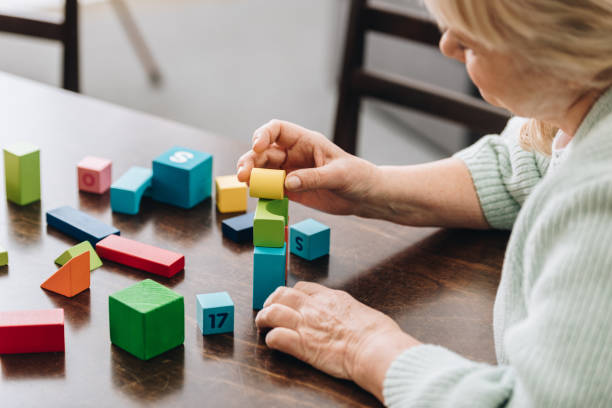 istock senior woman playing with wooden cubes on table 1089333092