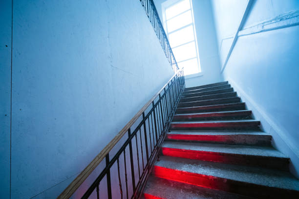 istock Looking up the scary distorted stairway. Stairs going up with red light on steps 1089338054