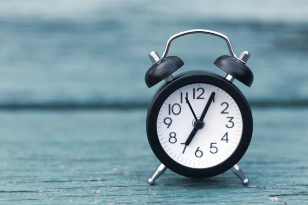 istock Retro alarm clock on green wooden background 1089339952