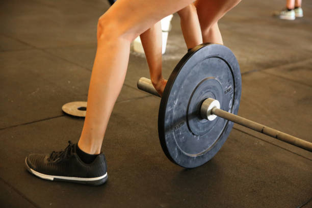 istock Young women preparing barbell for weightlifting 1089346134