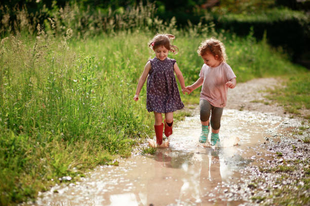 Girls playing in mud Smiling girls playing in muddy water. kids holding hands stock pictures, royalty-free photos & images