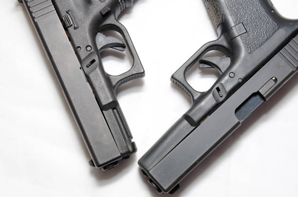 istock Two black semi automatic pistols, a 9mm and a 40 caliber on a white background 1089346824