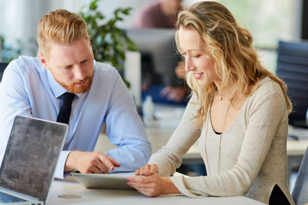 istock Corporate workers sitting in board room ad looking at tablet. 1089346882