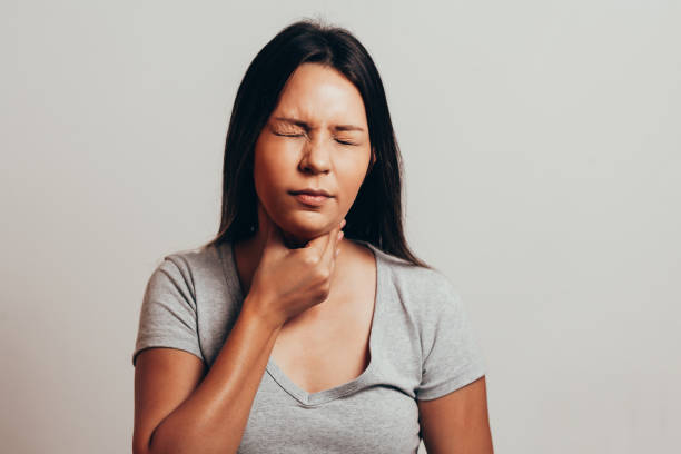 istock Woman suffering from sore throat over gray background 1089353174