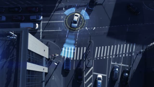 Top Down Aerial Drone: White Autonomous Self Driving Car Moving Through City. Concept: Artificial Intelligence Scans Surrounding Environment, Detecting Cars, Avoids Traffic Jams and Drives Safely.