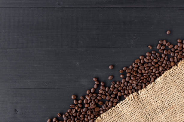 istock coffee beans in burlap sack on old wooden background. top view 1089363946