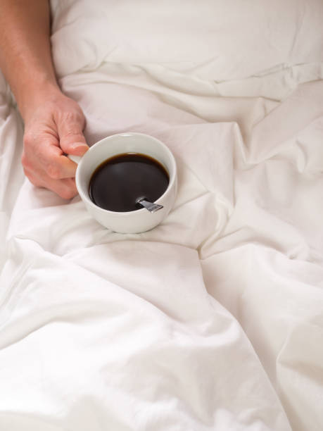 istock Quick breakfast - man in bed with a cup of coffee in hand 1089364240