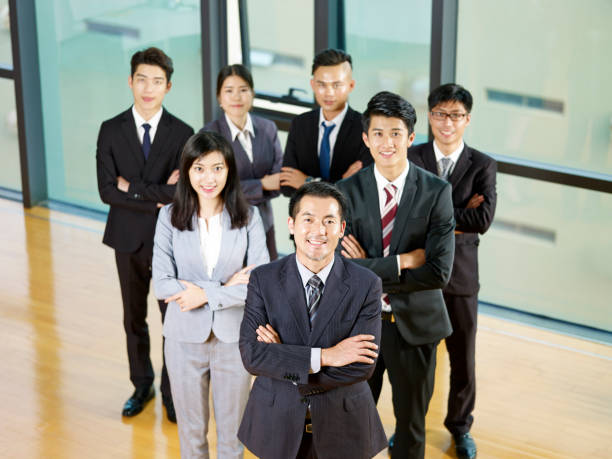 portrait of asian business team portrait of a successful asian business team led by a senior manager. organized group photos stock pictures, royalty-free photos & images
