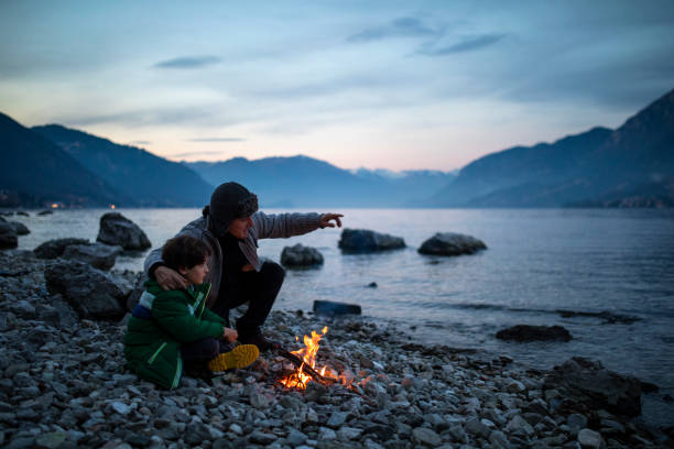 istock Father and son light a fire together on the beach 1089369736