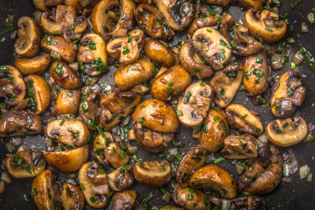 istock fresh mushrooms with herbs fried on a plate, top view, 1089369994