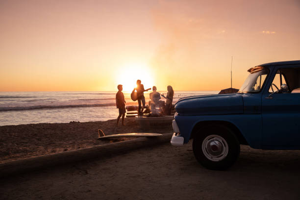 fête de famille sur la plage en californie au coucher du soleil - horizontal men women surfboard photos et images de collection