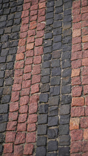 callejones de adoquines viejos, caminos. textura del pavimento de adoquines de color rojizo. fotografía de stock - paving stone avenue stone curve fotografías e imágenes de stock