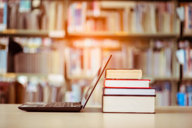 istock Bookshelves and laptops are placed on the library desk. 1089381818