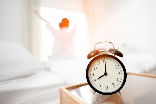 istock Closeup alarm clock in bed after waking up, sunlight in morning. 1089382664