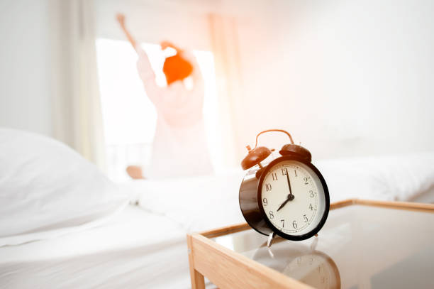 istock Closeup alarm clock in bed after waking up, sunlight in morning. 1089382666