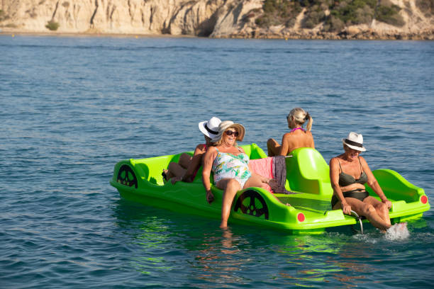 frauen in führungspositionen entspannend auf die sommer-meer - pedal boat stock-fotos und bilder