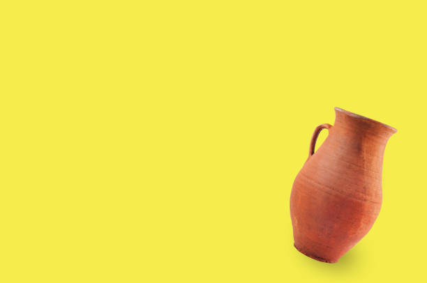 istock Single antique clay brown weathered and scratched vase with handle on yellow table with copy space for your text. Archeology excavations concept 1089395028