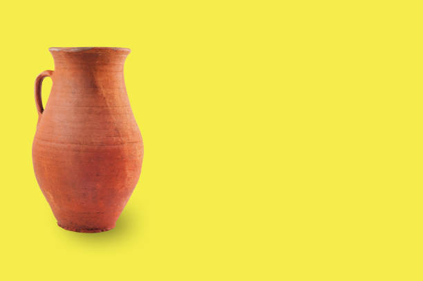 istock Single antique clay brown weathered and scratched vase with handle on yellow table with copy space for your text. Archeology excavations concept 1089395040