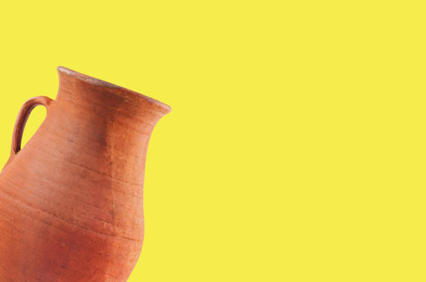 istock Single antique clay brown weathered and scratched vase with handle on yellow table with copy space for your text. Archeology excavations concept 1089395048