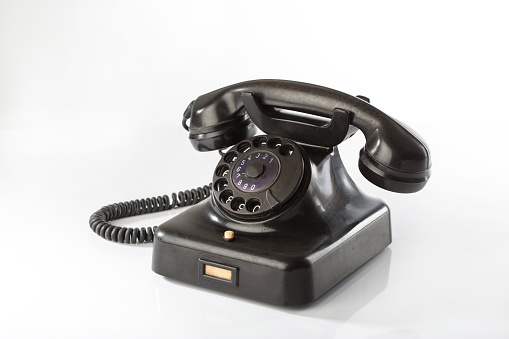 Black bakelite classic rotary phone isolated on white