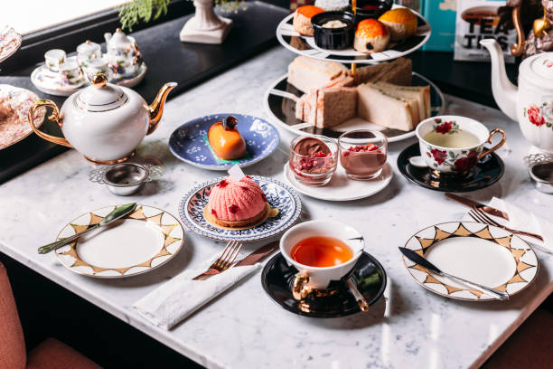 English afternoon tea set including hot tea, pastry, scones, sandwiches and mini pies on marble top table. English afternoon tea set including hot tea, pastry, scones, sandwiches and mini pies on marble top table. afternoon tea stock pictures, royalty-free photos & images