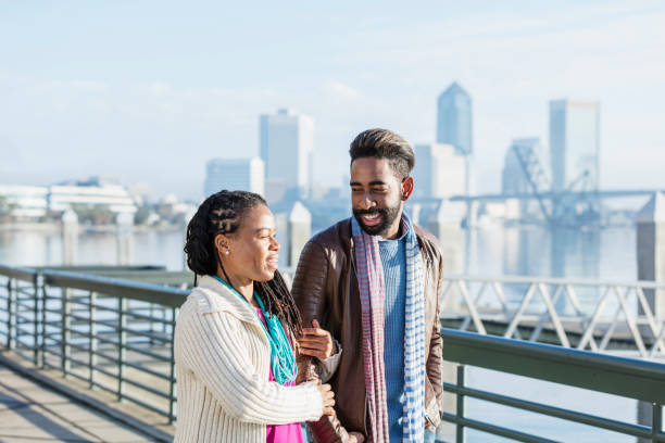 istock Mixed race couple walking together on a city waterfront 1089402670