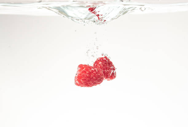 istock Raspberries splashing into crystal clear water with air bubbles background 1089407956
