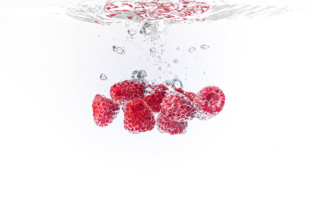 istock Raspberries splashing into crystal clear water with air bubbles background 1089410700