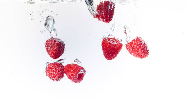 istock Raspberries splashing into crystal clear water with air bubbles 1089410744