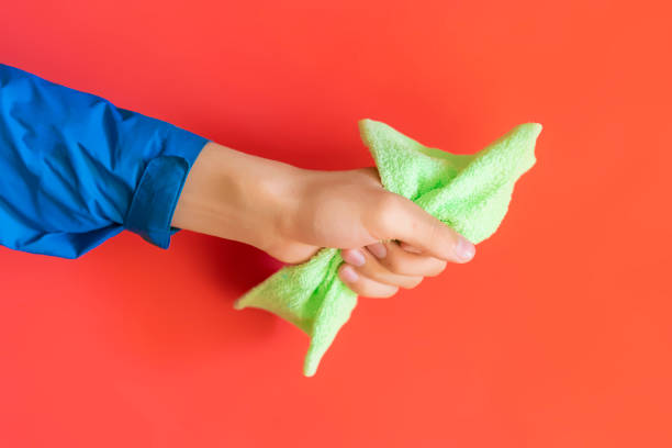 istock hand hold blue and yellow cleaning rag on red background isolated b 1089414158