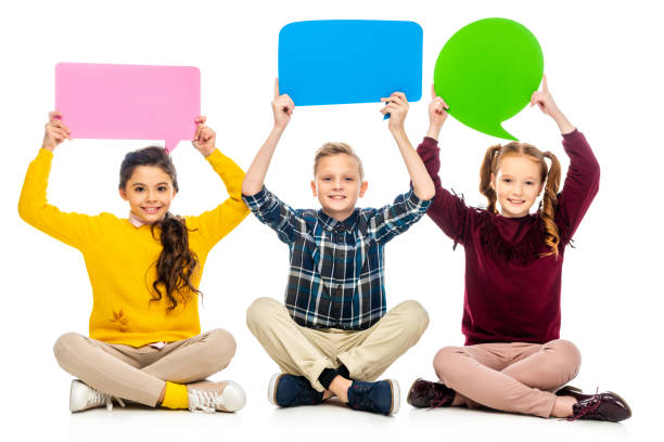 istock smiling kids sitting and holding speech bubbles over heads isolated on white 1089417796